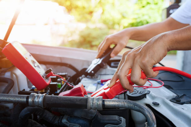 close up of auto mechanic jumping battery car.